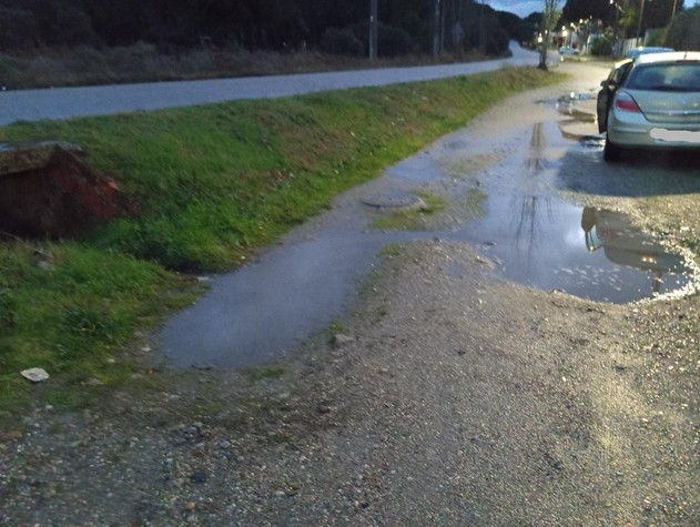 Estado de la calle, socavones y riachuelo tras lluvias.